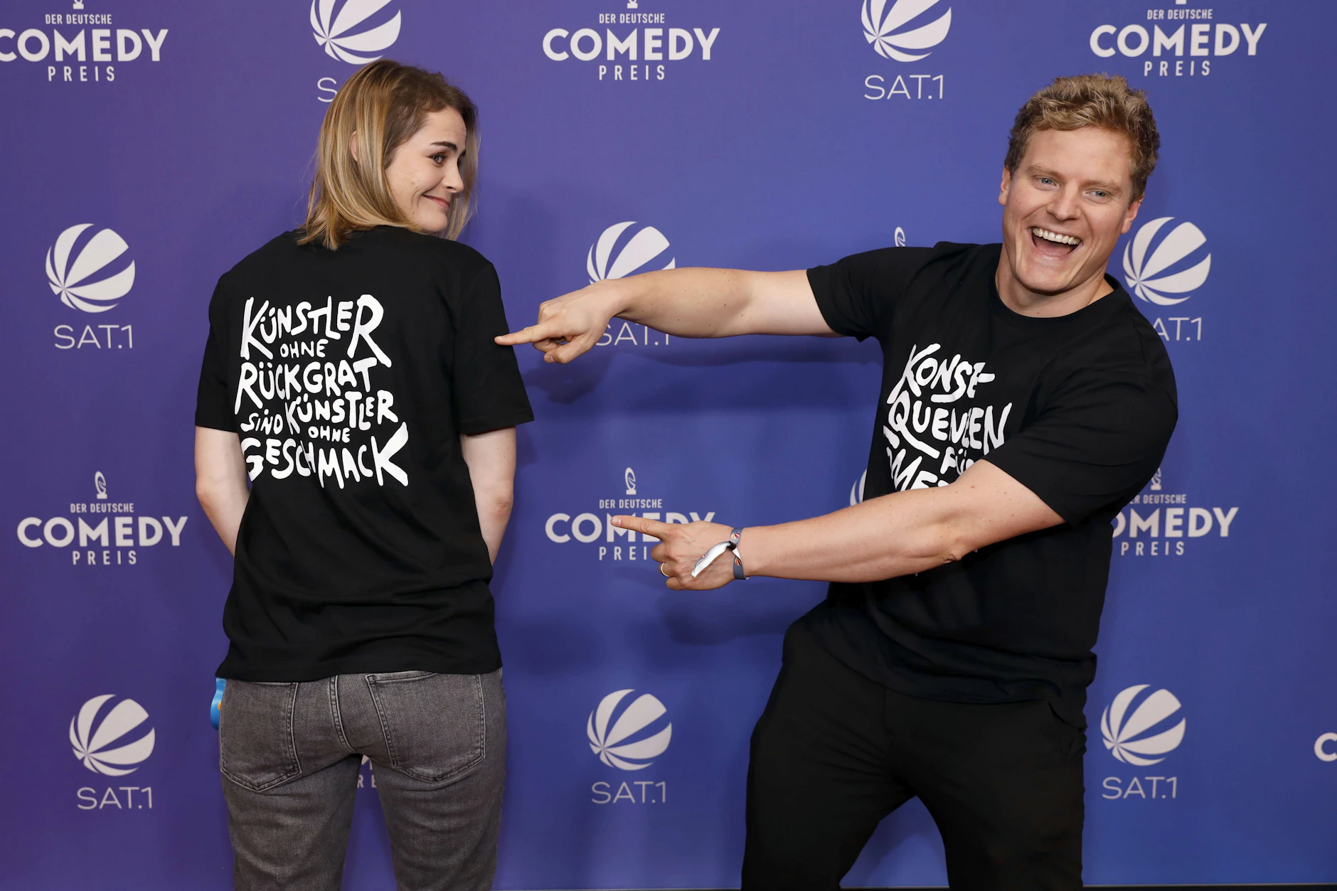 Hazel Brugger und Thomas Spitzer zeigen ihe T-Shirts bei der Verleihung des 25. Deutschen Comedypreises 2021.