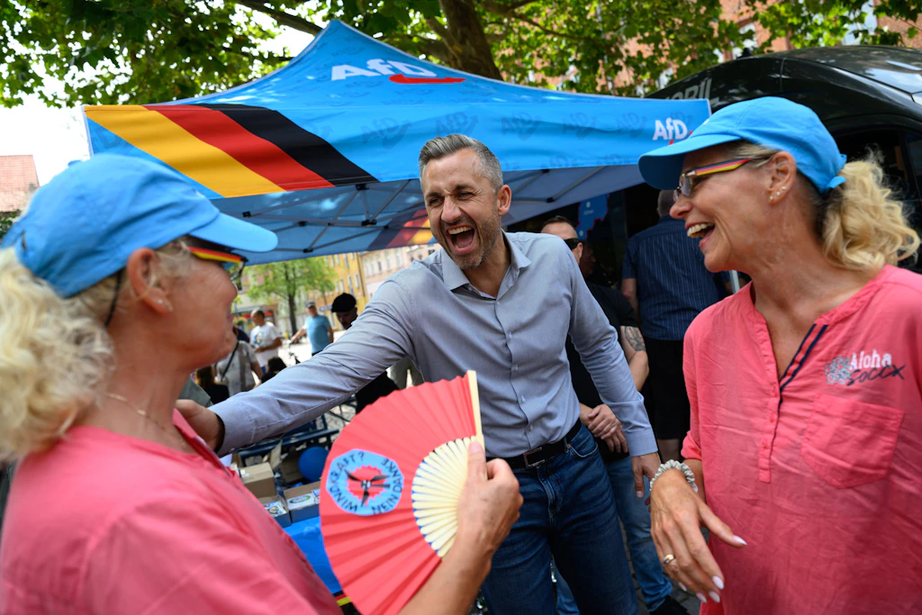 Ulrich Siegmund, Spitzenkandidat der AfD in Sachsen-Anhalt, unterhält sich mit dem Zwillingspaar Birgit (l) und Karin.
