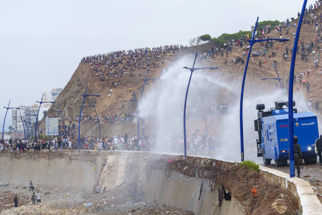 Marokkanische Einsatzkräfte versuchen, Migranten auf dem Weg nach Ceuta mit Wasserwerfern aufzuhalten.