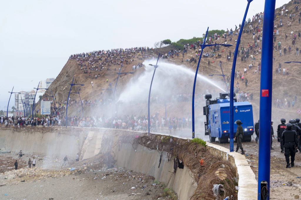 Marokkanische Einsatzkräfte versuchen, Migranten auf dem Weg nach Ceuta mit Wasserwerfern aufzuhalten.
