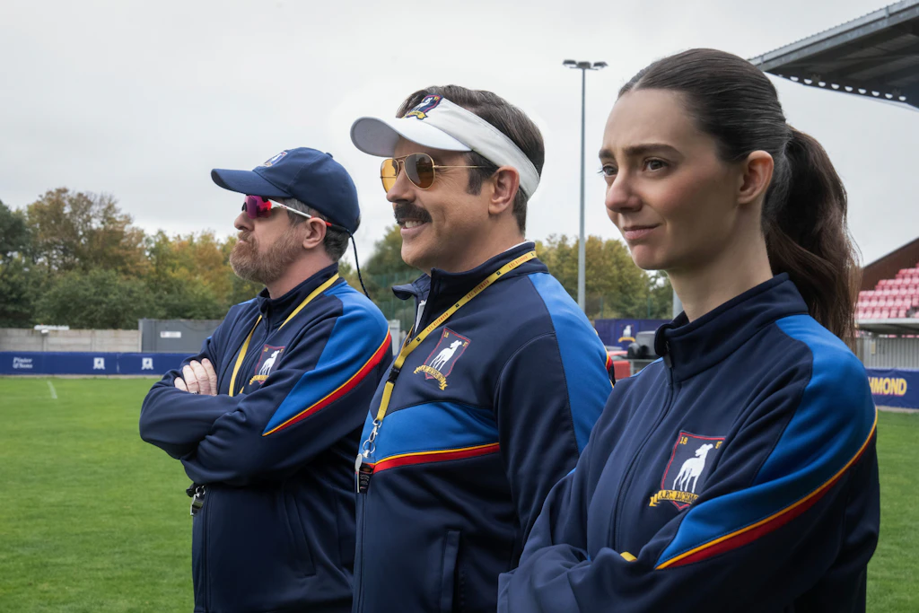 Brendan Hunt, Jason Sudeikis und Tanya Reynolds in einer Szene der Serie „Ted Lasso“. Die 4. Staffel startet am 5. August auf Apple TV.