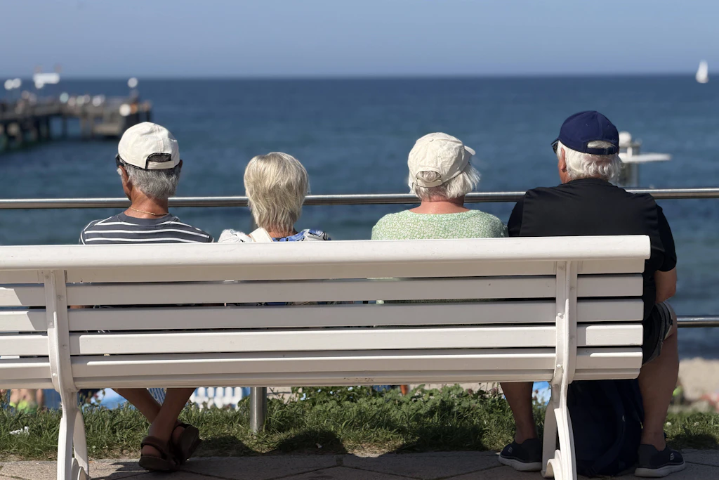 Vier Menschen im Ruhestand blicken auf die Ostsee. Wie viel am Monatsende bleibt, entscheidet sich Jahrzehnte vorher im Rentenkonto. (Symbolbild)