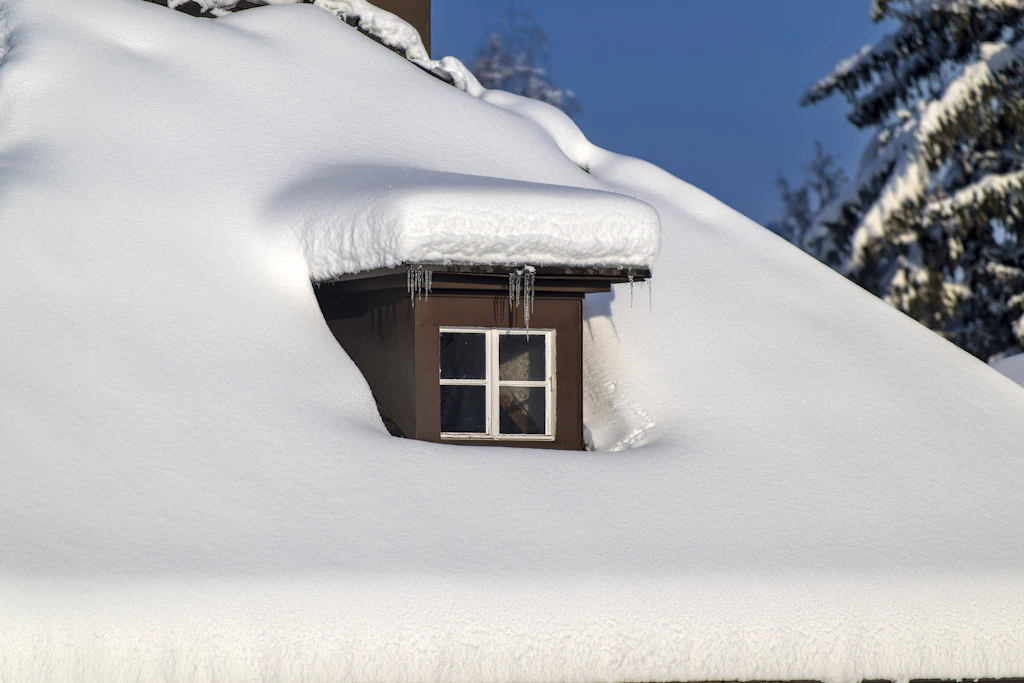 Meterhoher Schnee auf einem Hausdach. Ob der kommende Winter solche Bilder liefert, entscheidet sich erst im Januar am Polarwirbel. (Symbolbild)
