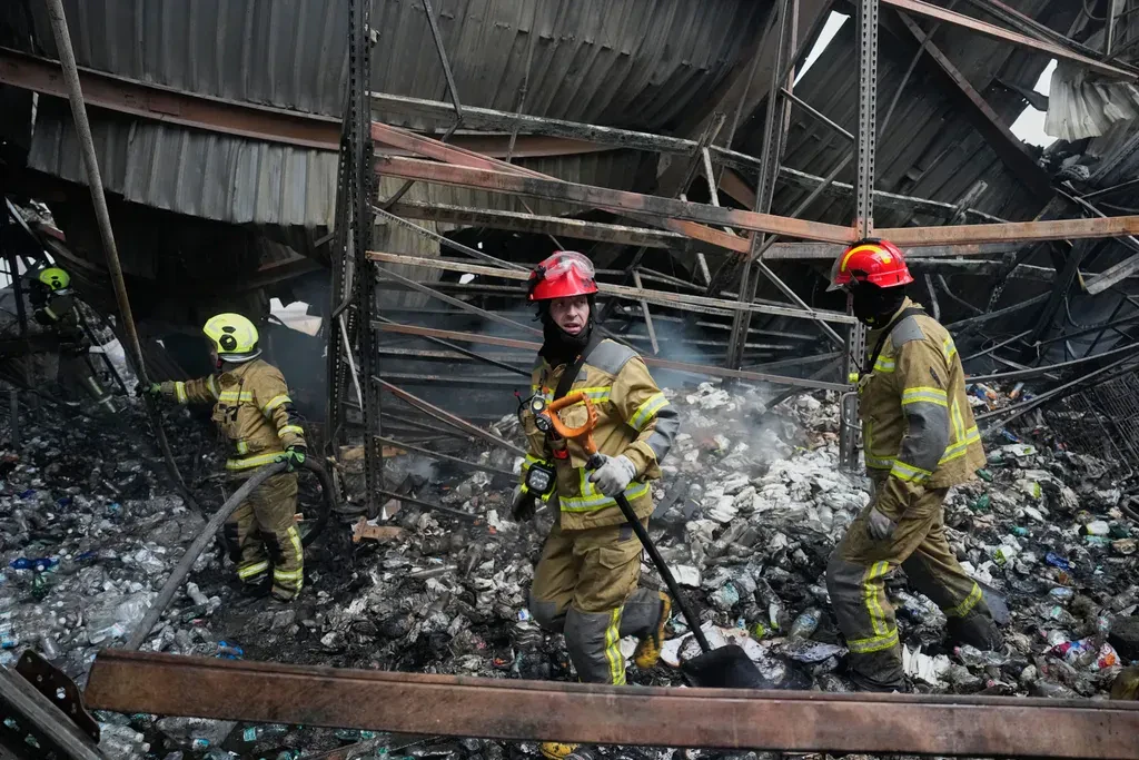 Feuerwehrleute in einer zerstörten Lagerhalle im Gebiet Kiew. Russland traf bei dem nächtlichen Angriff mehrere Betriebe und Logistikstandorte.