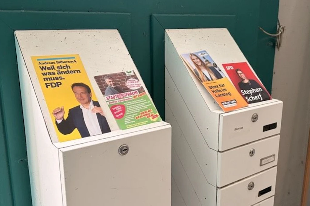 Auf Briefkästen liegen Flyer von FDP, Grünen, CDU und SPD. „Taktisch Wählen“ wirbt um Zweitstimmen für Grüne und SPD.