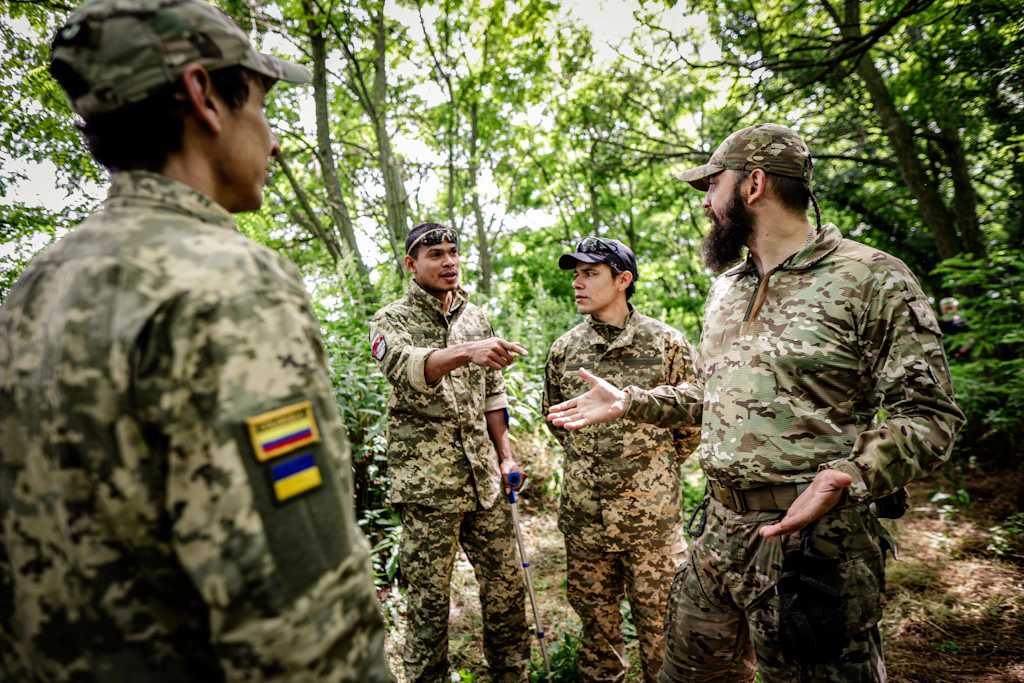Ein kolumbianischer Kämpfer mit den Flaggen Kolumbiens und der Ukraine an seiner Uniform.