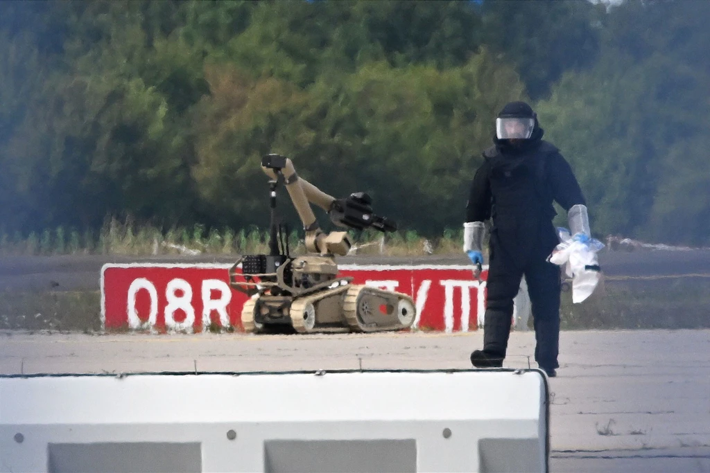 Ein Kriminaltechniker ist im August neben einem Sprengroboter auf dem Flughafen Leipzig/Halle im Einsatz. Nach dem Drohnen-Vorfall hatten Spezialisten eine Drohne mit einer Sprengvorrichtung entschärft.