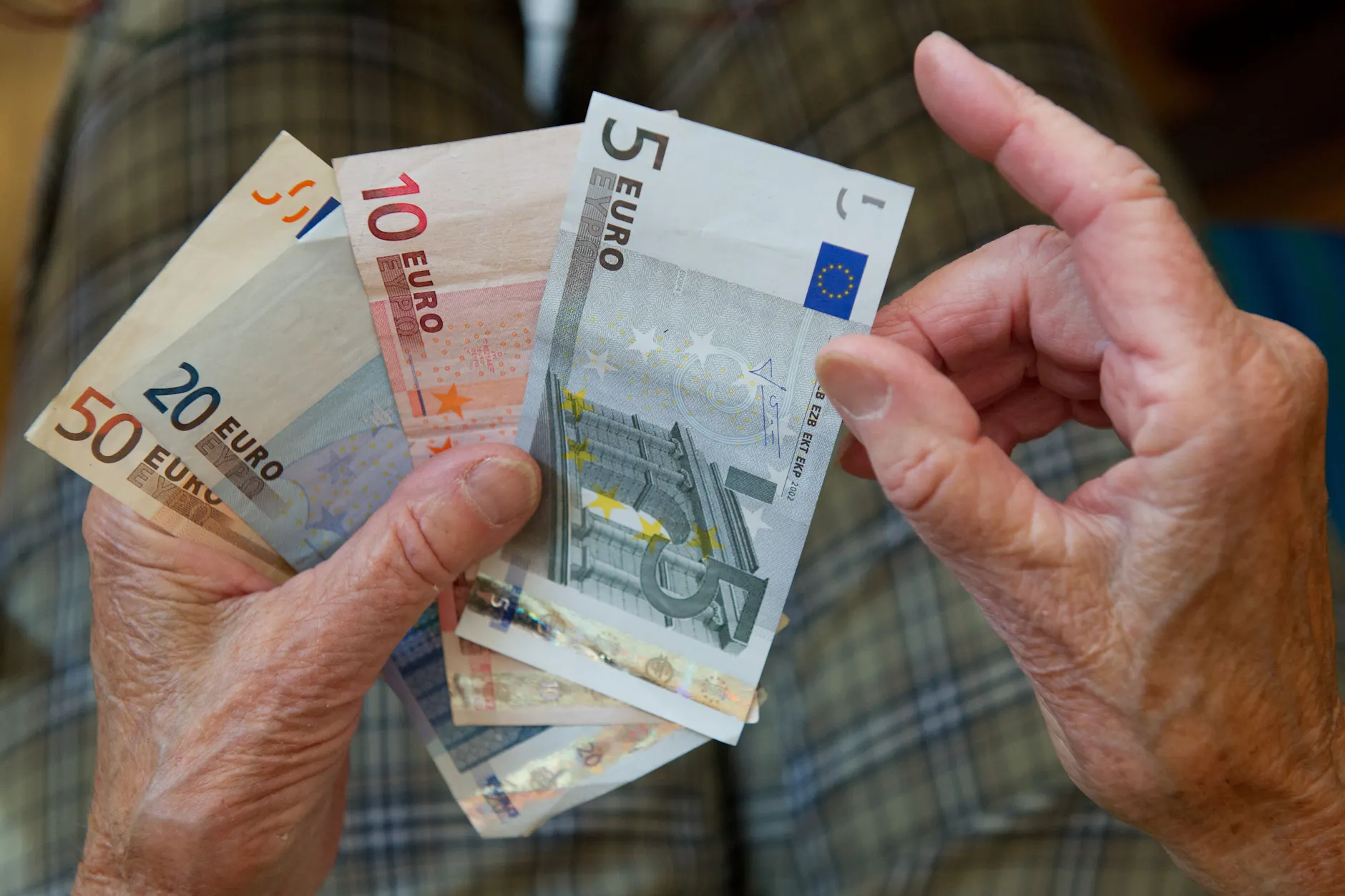 Eine ältere Frau zählt Geld.