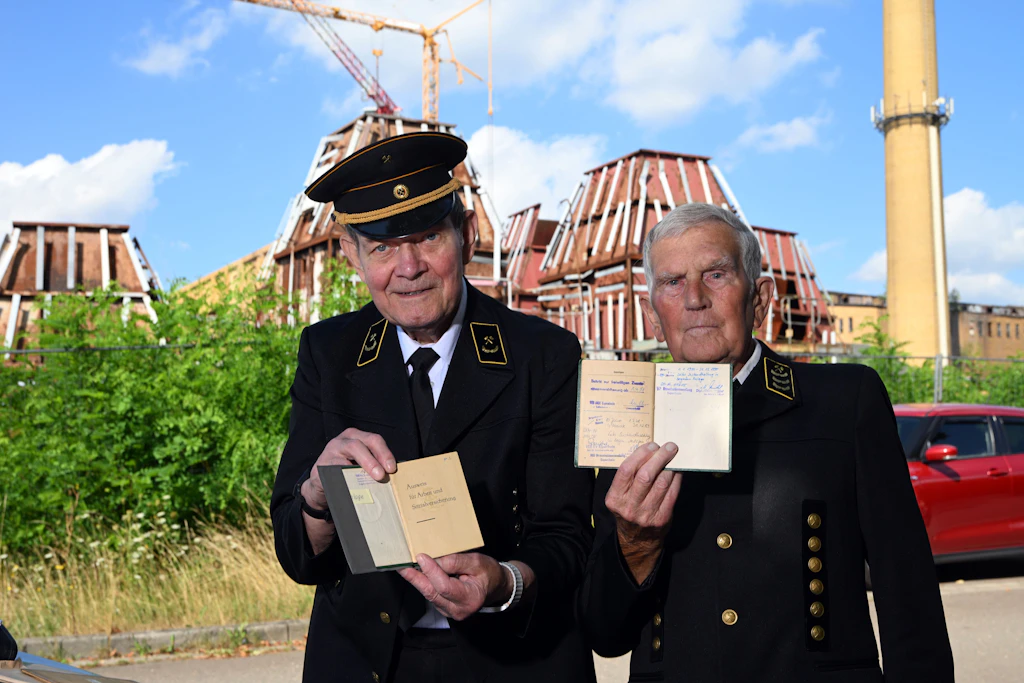 Arthur Hähnel (84) und Günther Freitag (87) vor der alten Schwelerei&nbsp; bei Espenhain. Ihnen wurde die Zusatzrente wurde bei Renteneintritt aberkannt. Sie zeigen ihre SV-Ausweise, in denen „bergmännische Tätigkeit“ verzeichnet ist.