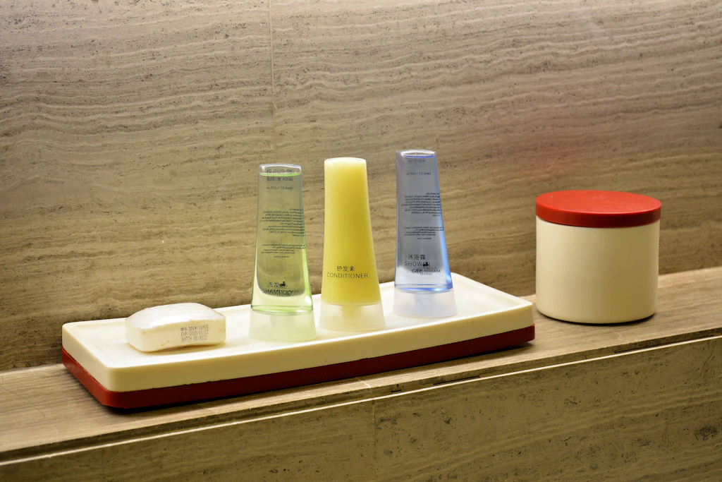 Shampoo, Conditioner und Duschgel in Mini-Fläschchen auf einer Ablage im Hotelbad: Diese Einwegverpackungen aus Kunststoff verbietet die EU.