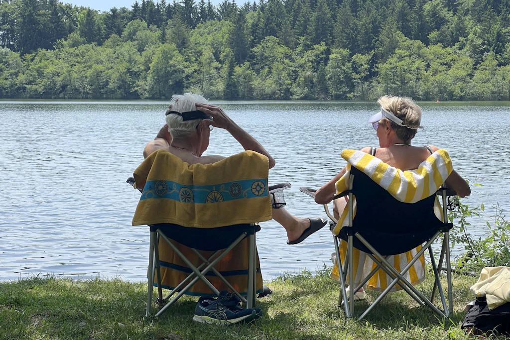 Ein älteres Paar genießt das warme Wetter am Steinsee bei München.