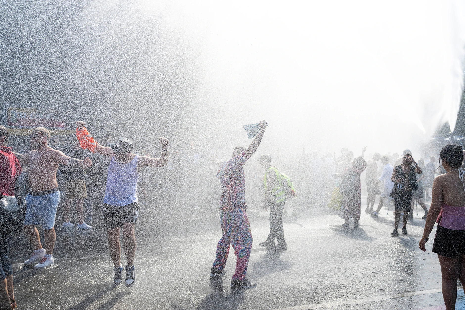 Zur Abkühlung tanzen die Techno-Fans unter dem Wassernebel eines Wasserwerfers der Polizei.