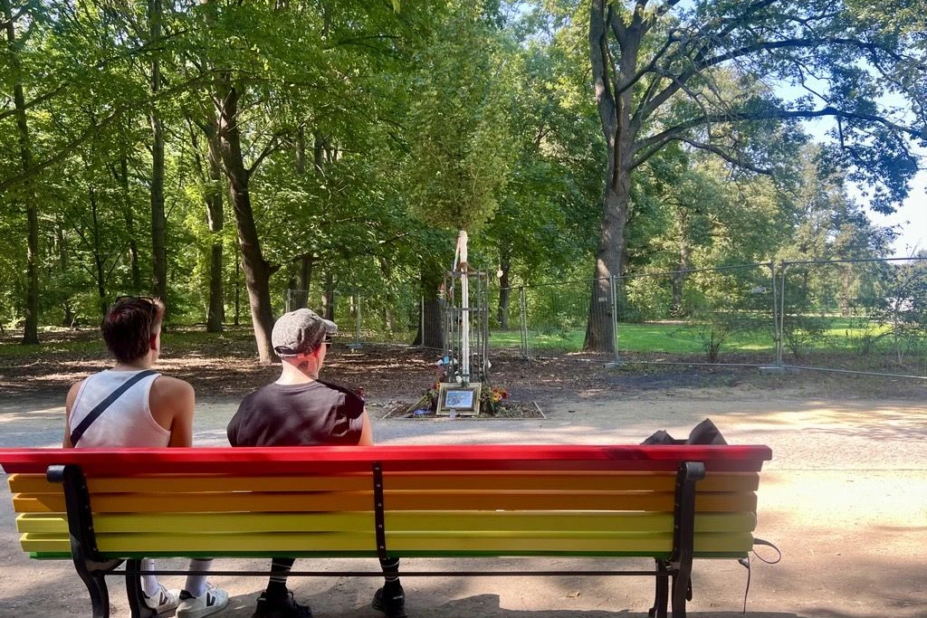 Während im Hintergrund die Musik aus den Boxen dröhnt, suchen zwei Besucher am Tatort des CSD-Anschlags einen Moment der Stille.