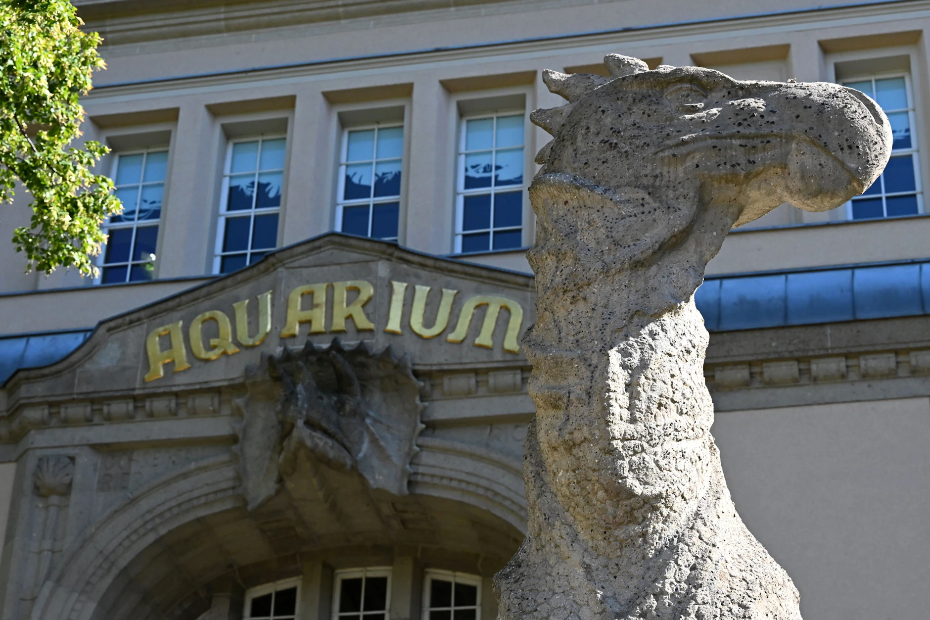 Vor dem Aquarium des Berliner Zoos steht eine fünf Meter hohe Steinfigur eines Dinosauriers.