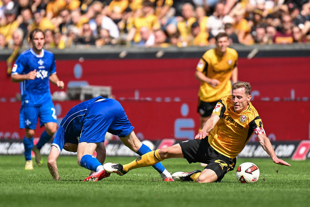 Knackpunkt zwischen Dynamo Dresden und dem SV Darmstadt 98: Kai Klefisch (l.) kassiert nach diesem Zweikampf gegen Dresdens Niklas Hauptmann die Gelb-Rote Karte.