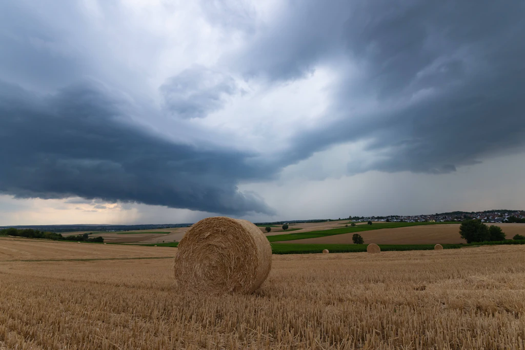 Gewitterwolken über einem abgeernteten Feld: Der Deutsche Wetterdienst erwartet am Montag Starkregen bis 35 Liter pro Quadratmeter im Süden und in der östlichen Mitte. (Symbolbild)