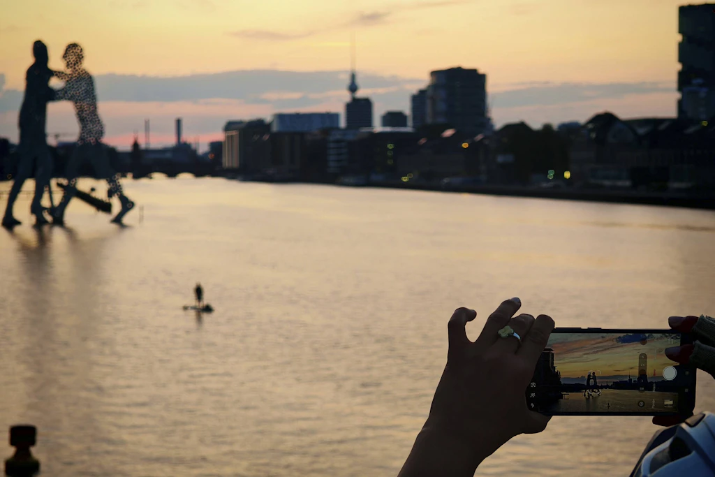 Berlin hat viel zu bieten. Hier fotografiert eine Touristin die Skulptur „Molecule Man“ in der Spree.