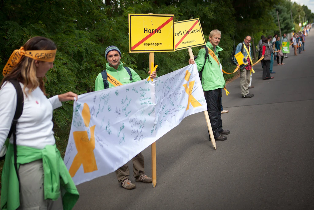 Mit einer Menschenkette zwischen Kerkwitz (Lausitz) und Grabice (Polen) demonstrieren betroffene Bürger gegen die Ausweitung des Braunkohletagebaus, für die weitere Dörfer abgebaggert und Anwohner umgesiedelt werden müssen.