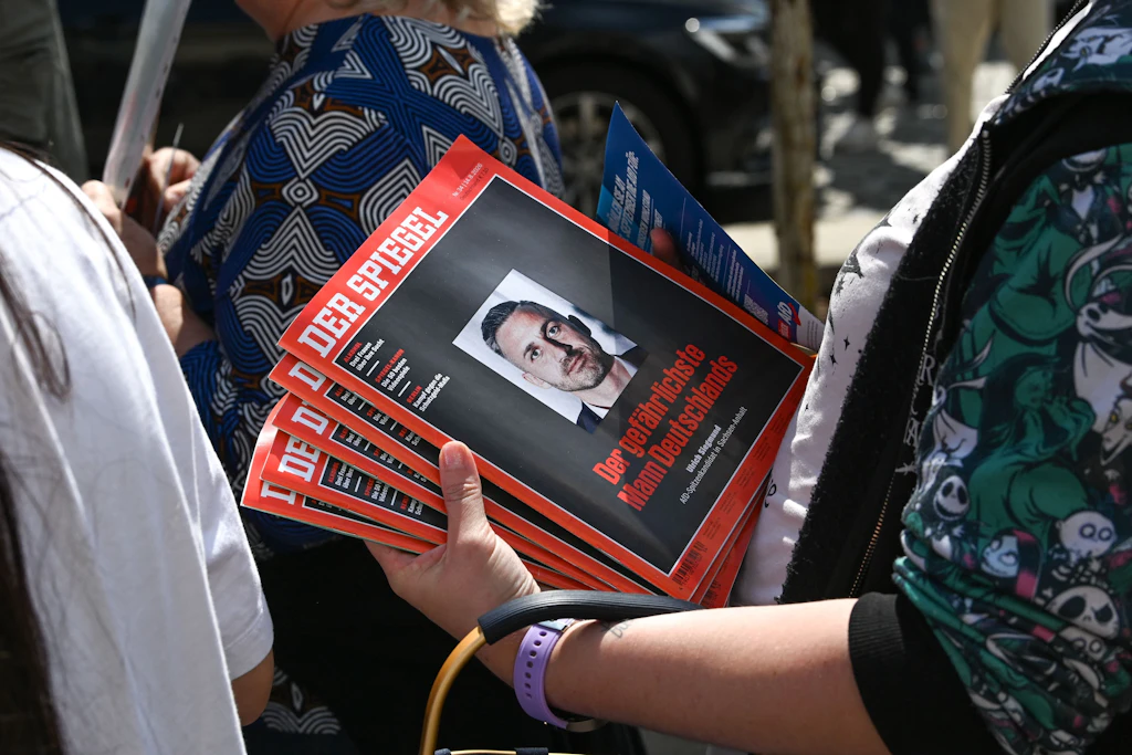 Anhänger der AfD warten mit Ausgaben des Magazins „Der Spiegel“ an einem Wahlkampfstand der Partei, um sie von Spitzenkandidat Ulrich Siegmund signieren zu lassen.