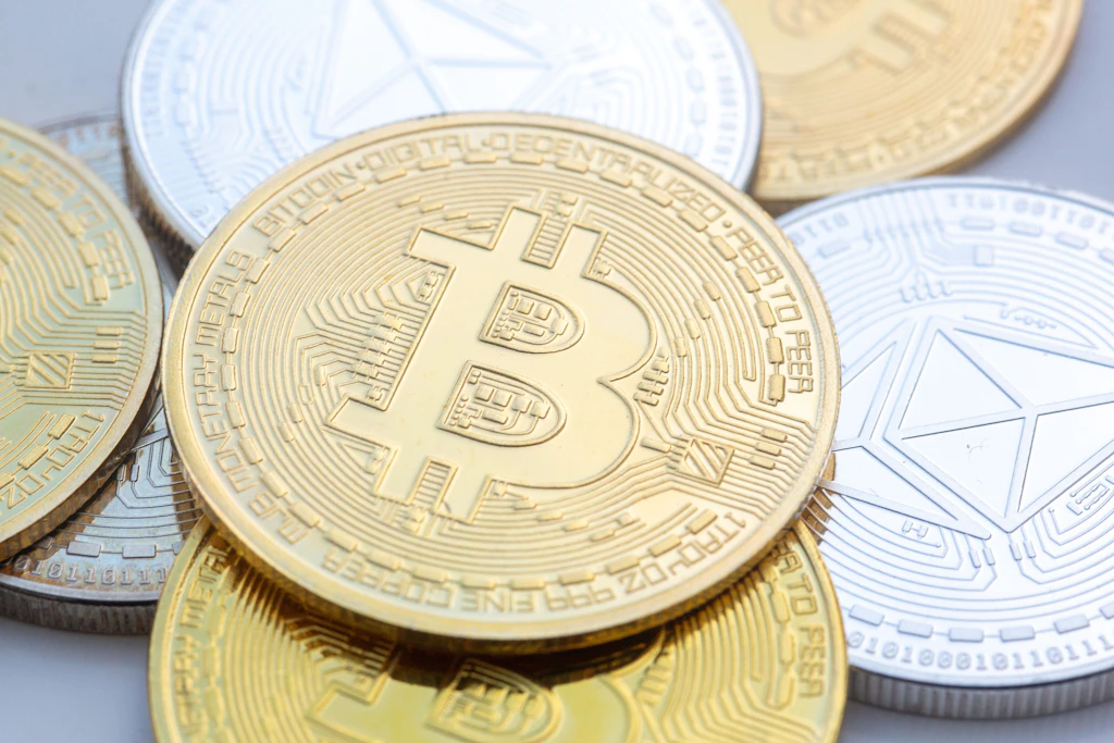 Münzen mit den Symbolen von Bitcoin (M) und Ethereum.