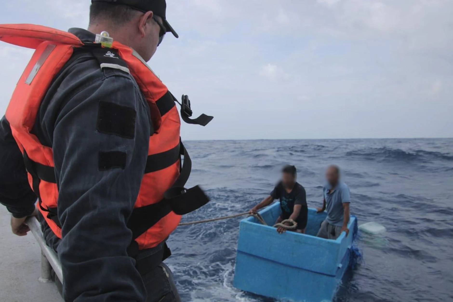Die beiden schiffbrüchigen Fischer in der Kühlbox, wie sie von einem Patrouillenboot der Marine aufgenommen werden.