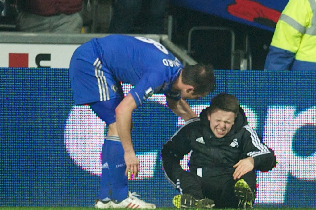 Charlie Morgan sitzt nach dem Tritt von Eden Hazard mit schmerzverzerrtem Gesicht am Spielfeldrand.