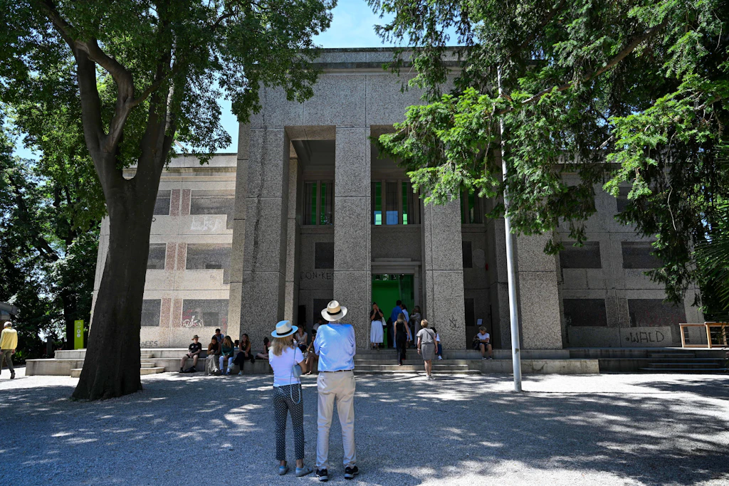 Die Künstlerin Sung Tieu verwandelte den deutschen Pavillon auf der Biennale in Venedig 2026 in einen ostdeutschen Plattenbau. Für die Arbeit „Human Dignity Shall Be Inviolable“ bedeckte sie die Fassade mit drei Millionen Marmormosaiksteinen, um einen Wohnblock aus der Gehrenseestraße in Berlin-Lichtenberg nachzubilden.