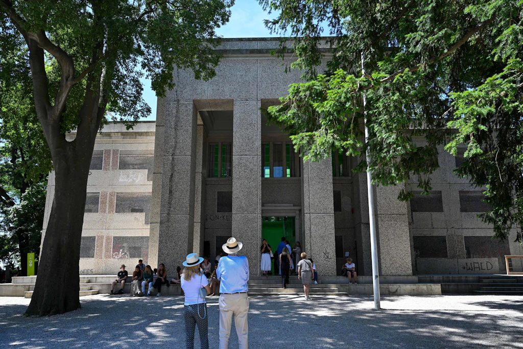 Die Künstlerin Sung Tieu verwandelte den deutschen Pavillon auf der Biennale in Venedig 2026 in einen ostdeutschen Plattenbau. Für die Arbeit „Human Dignity Shall Be Inviolable“ bedeckte sie die Fassade mit drei Millionen Marmormosaiksteinen, um einen Wohnblock aus der Gehrenseestraße in Berlin-Lichtenberg nachzubilden.