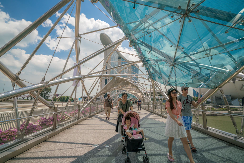 Familien spazieren über eine Brücke in Singapur. Der Stadtstaat wird immer älter.