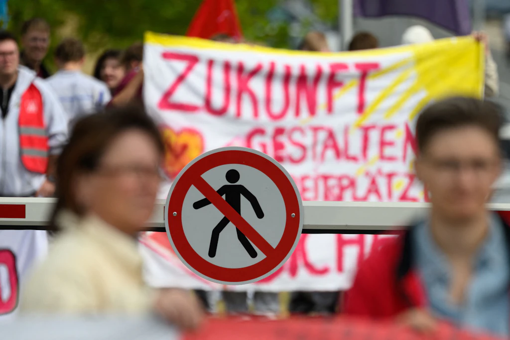 Beschäftigte des Volkswagenwerkes Zwickau haben sich vor dem Werkstor versammelt.
