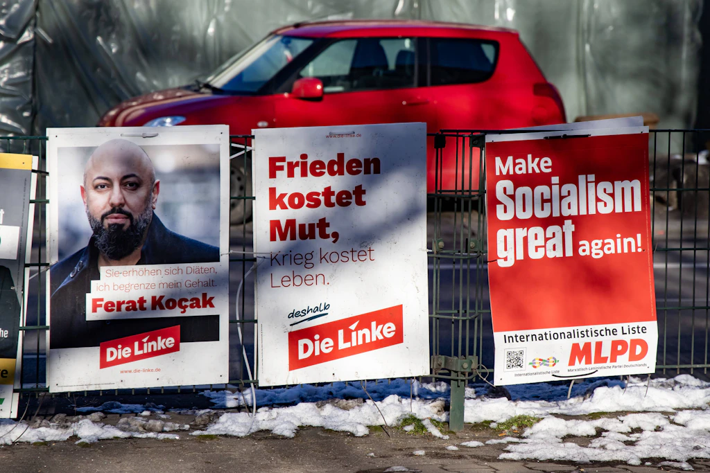 Wahlplakate der Linken mit dem Direktkandidat für Neukölln, Ferat Kocak, und der MLPD am Hermannplatz in Berlin am 18. Februar 2025