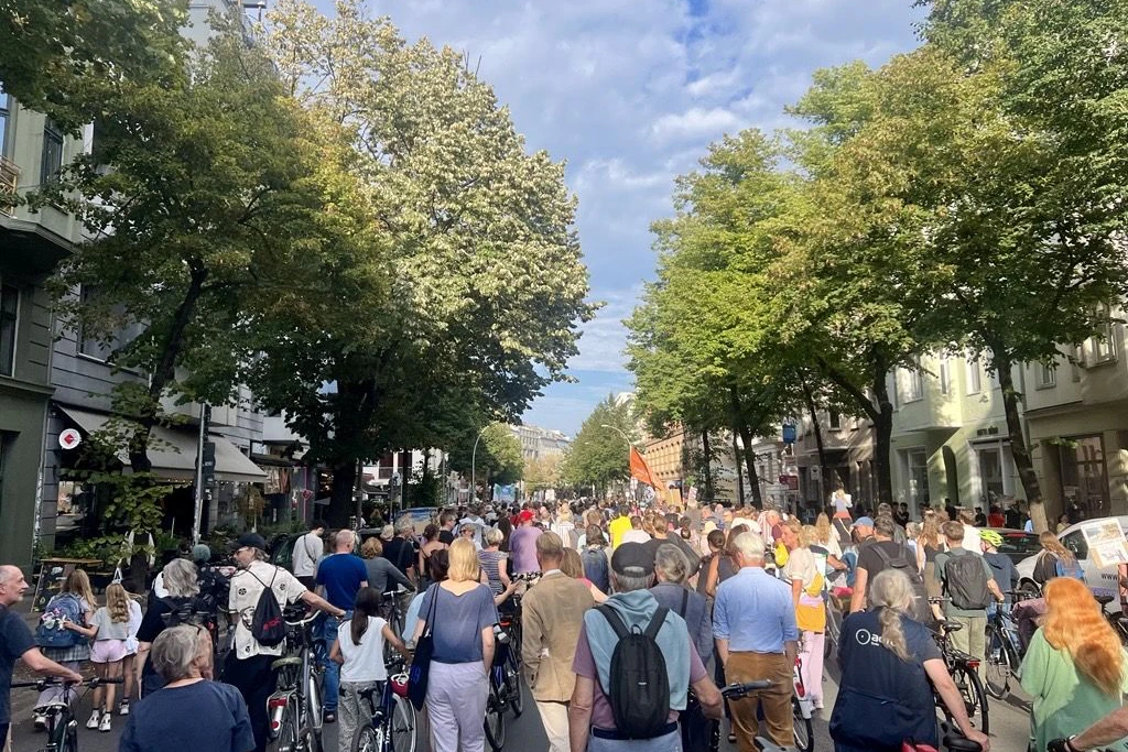 Die Demonstration zieht über die Torstraße in Berlin-Mitte. Links und rechts ist die Straße von Bäumen gesäumt, die gefällt werden sollen.