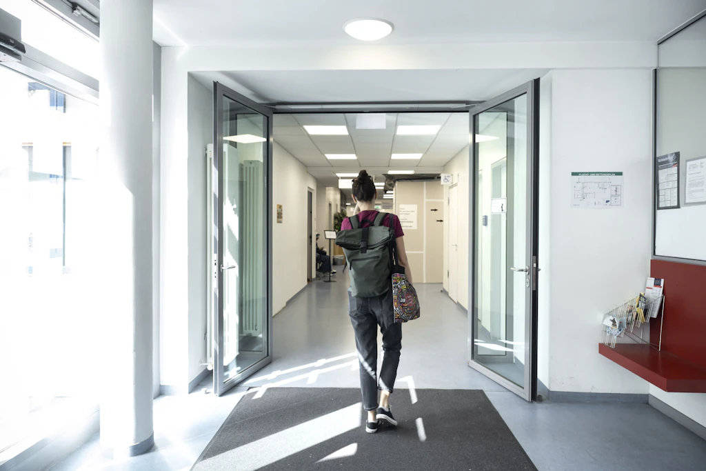 Kurze Wege von Arzt zu Arzt: eine Frau in einem Flur des Gesundheitszentrums Gropiusstadt