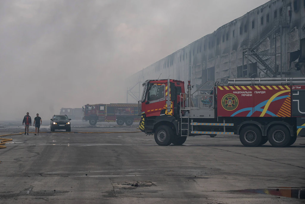Feuerwehrfahrzeuge vor einem beschädigten Lagerhaus in der Region Kiew nach den russischen Angriffen vom 27. August.