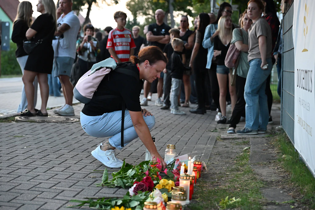 Anwohner, Mitschüler und Freunde legen Blumen an der Schule ab.