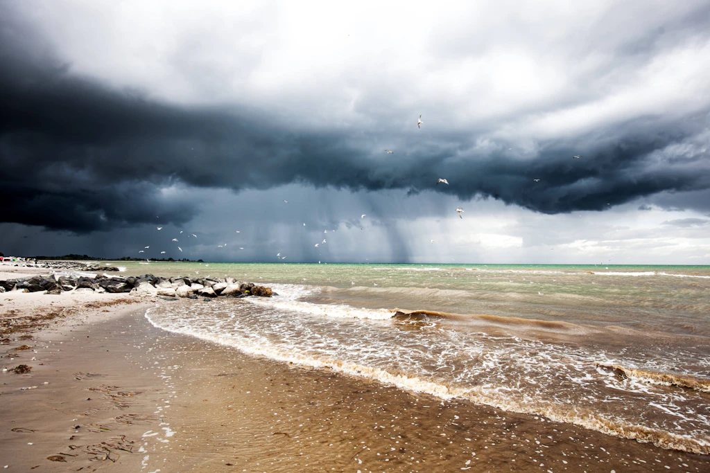 Dunkle Wolken und Regenschleier über der Küste: Der Deutsche Wetterdienst erwartet an diesem Samstag an der Nordsee einzelne Gewitter mit Sturmböen bis 80 km/h. (Symbolbild)