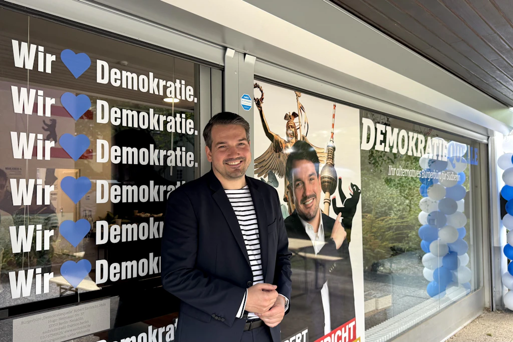 AfD-Abgeordnete Robert Eschricht am Tag der Eröffnung seines Büro in Neukölln - weniger Meter weiter skandieren Demonstranten gegen ihn und die AfD.