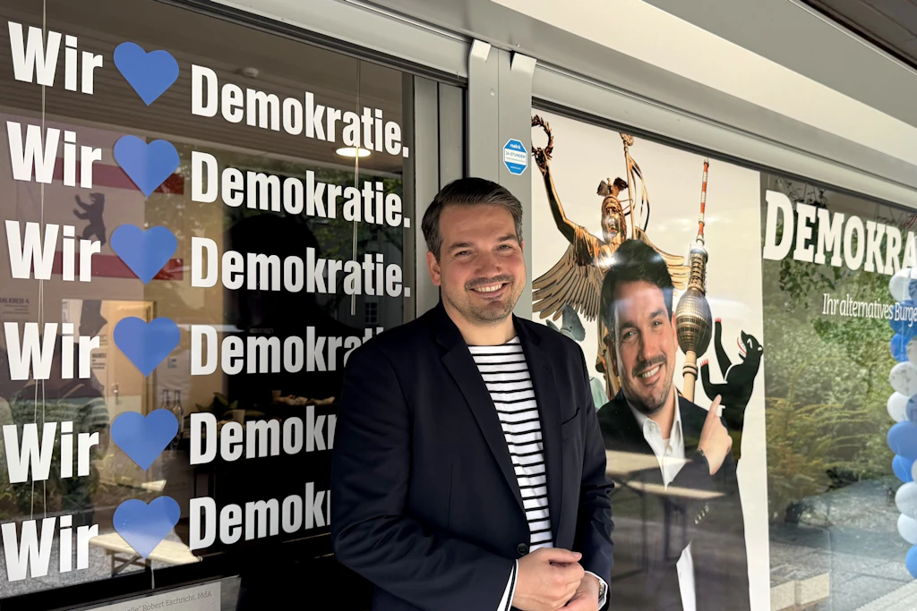 Der AfD-Abgeordnete Robert Eschricht am Tag der Eröffnung seines Büros in Neukölln – wenige Meter weiter skandieren Demonstranten gegen ihn und die AfD.