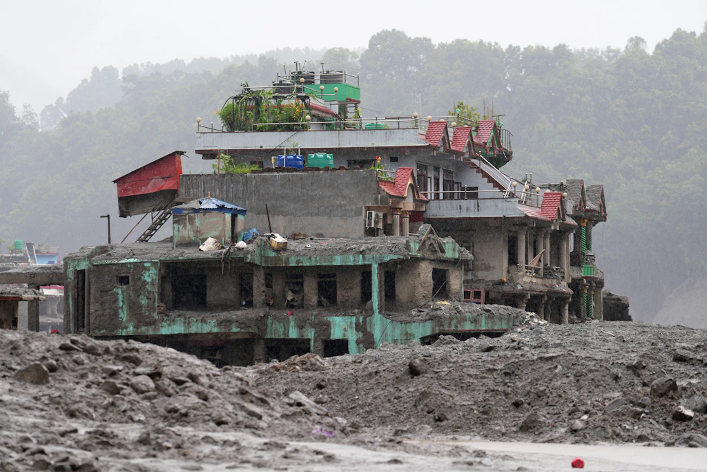 Ein beschädigtes Haus steht inmitten der Trümmer einer Sturzflut im Distrikt Nuwakot in Nepal.