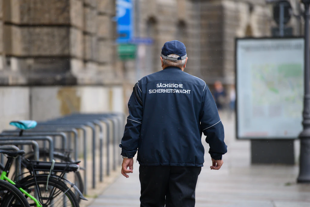 Ein ehrenamtlicher Mitarbeiter der Sächsischen Sicherheitswacht läuft einen Fußweg in der Innenstadt entlang.