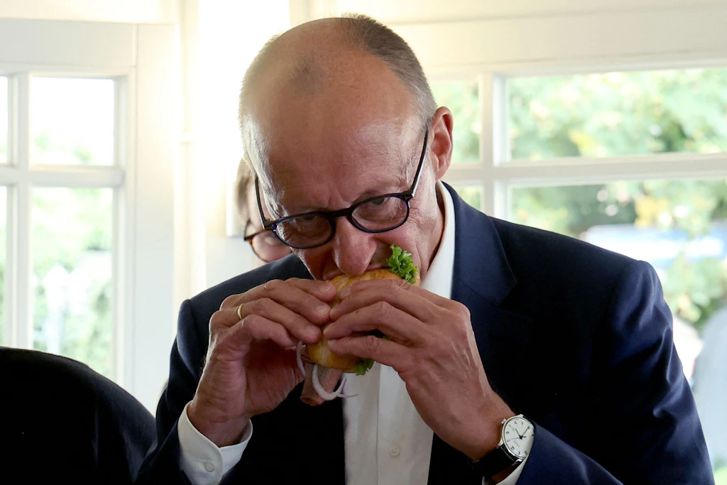 Der Bundeskanzler genießt ein Fischbrötchen.
