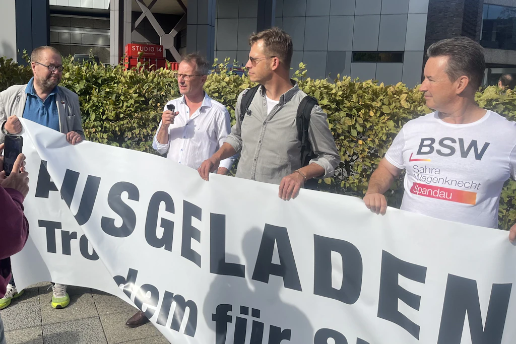 Der Berliner BSW-Chef Alexander King (mit Mikrofon) spricht bei der Kundgebung vor dem RBB-Haus. Auf dem Verdi-Podium im Inneren war er nicht erwünscht.