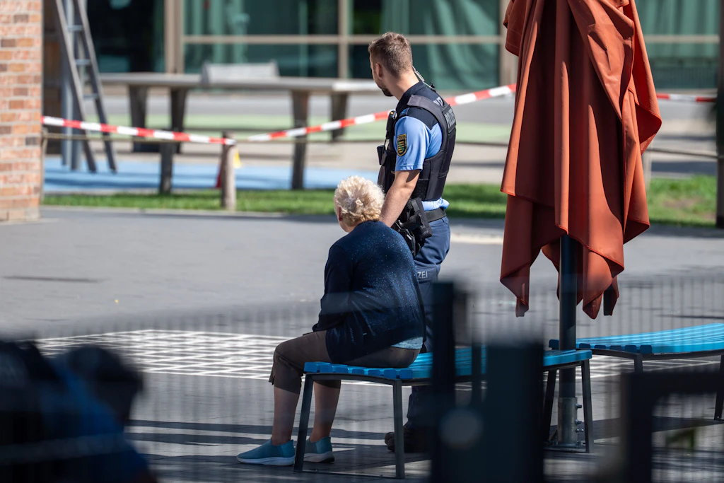 Die Seniorin sitzt auf einer Bank im Schulhof, muss von der Polizei ihre Fahrtüchtigkeit prüfen lassen.