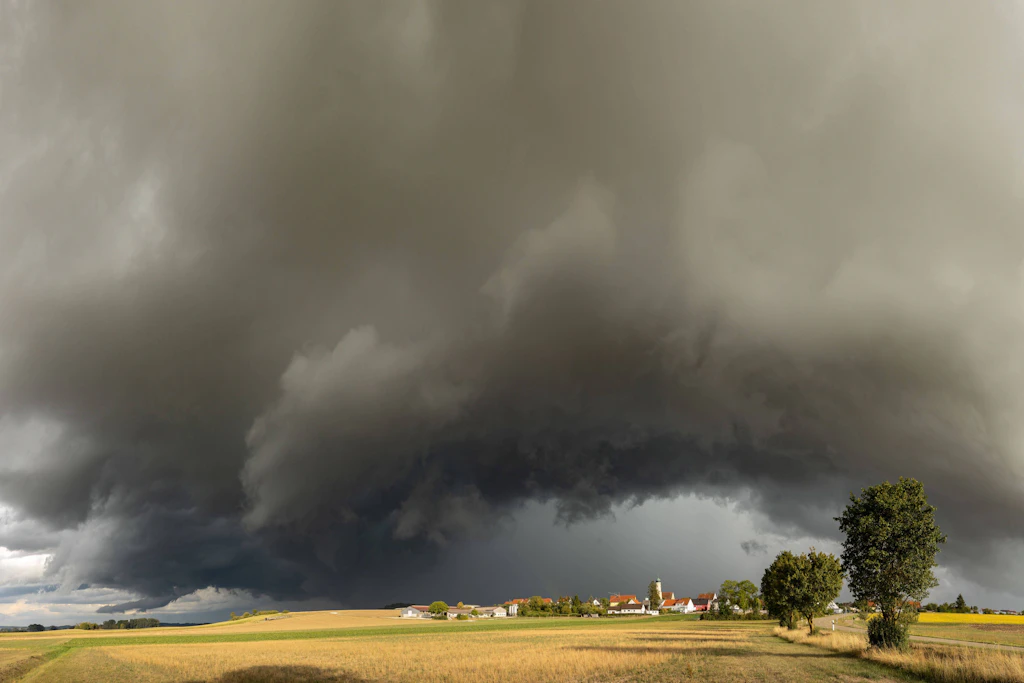 Eine Böenwalze zieht über ein Dorf: Der Deutsche Wetterdienst warnt am Montag über der Nordhälfte vor Gewittern mit Sturmböen bis 85 km/h. (Symbolbild)