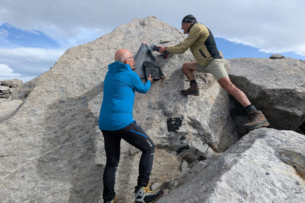 Gerd Frühwirth (l) und Roland Kals (r) vom Österreichischen Alpenverein (ÖAV) entfernen die Gipfeltafel der Bergspitze, die bisher nach Wolfgang Pillewizer benannt war.