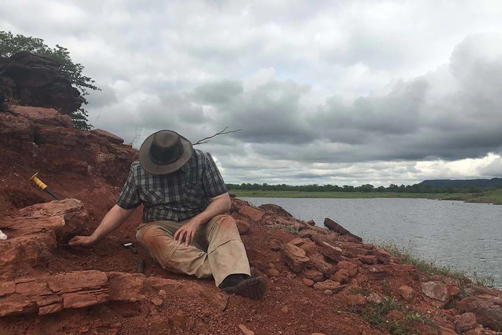 Der Paläontologe Paul Barrett legt am Ufer des Karibasees Fossilien von Musango matusadonaensis frei.