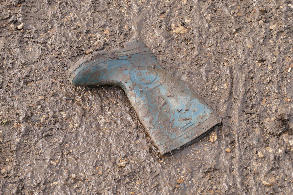 Ein zurückgelassener Gummistiefel steckt im Schlamm des Festivalgeländes. Nach den Regenfällen ließen Zehntausende ihre Ausrüstung einfach liegen.