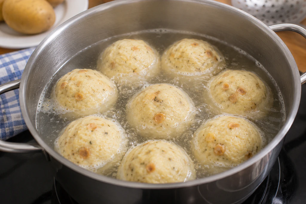 Die Knödel werden in siedendem Wasser zubereitet. Das Wasser sollte aber nicht kochen, sonst besteht die Gefahr, dass die Knödel zerfallen.