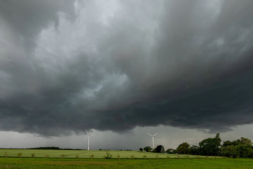 Dunkle Wolkenkante über einem Feld im Norden: Ab den Mittagsstunden erwartet der Wetterdienst in der Nordhälfte Sturmböen bis 85 km/h und einzelne kräftige Gewitter. (Symbolbild)