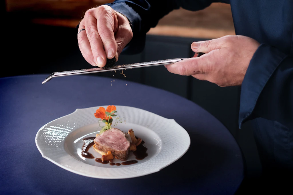 Letzte Handgriffe: Der Trüffel wird über das zartrosa gegarte Kalbsfilet gerieben, das auch zur Hope-Gala serviert wird.